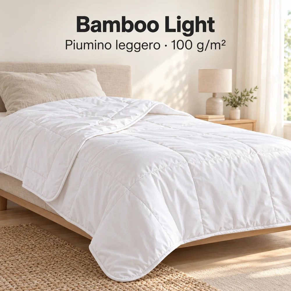 Piumino Bamboo Light bianco da 100 g/m² aperto sul letto con un risvolto morbido