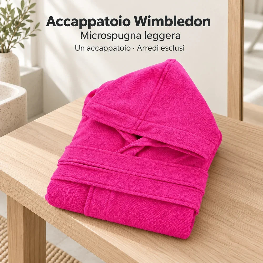 Accappatoio Wimbledon Fucsia piegato su una panca in un bagno neutro, con cappuccio e cintura visibili.
