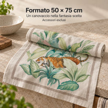 Formato 50 × 75 cm: un canovaccio Segreto Tropicale parzialmente arrotolato sul piano. Foto illustrativa: Segreto Tropicale. Accessori esclusi.