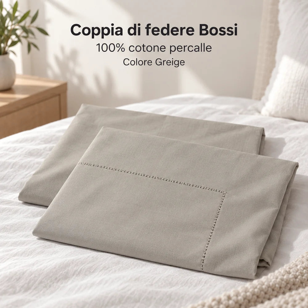Due federe Greige vuote, piegate basse e sfalsate sul letto. Foto illustrativa: Greige. Guanciali, arredi e accessori esclusi.