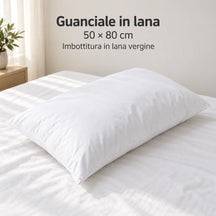 Guanciale in lana Bianco disteso sul letto, formato 50 × 80 cm. Arredi e accessori esclusi.