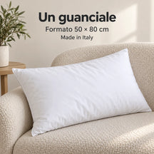 Un guanciale in lana Bianco appoggiato sulla poltrona, formato 50 × 80 cm. Arredi e accessori esclusi.