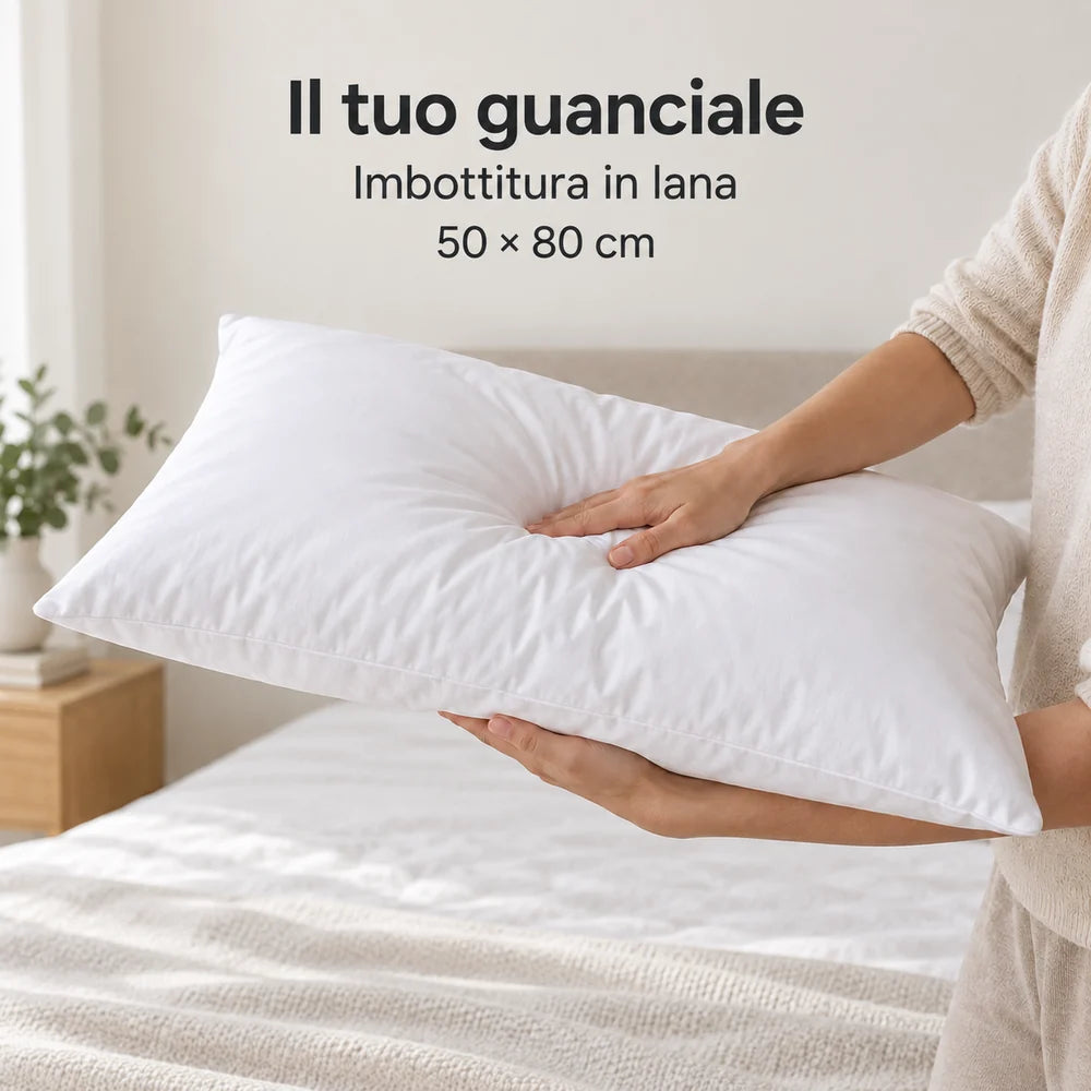 Guanciale in lana Bianco sostenuto dalle braccia e leggermente compresso. Arredi e accessori esclusi.